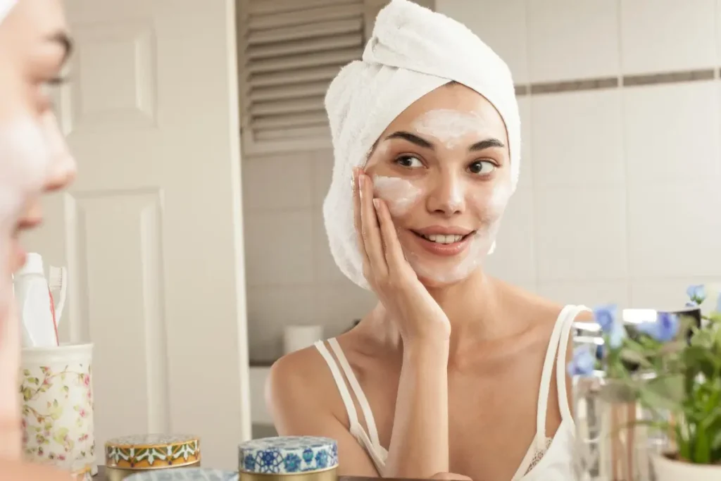 Mulher aplicando creme hidratante no rosto.