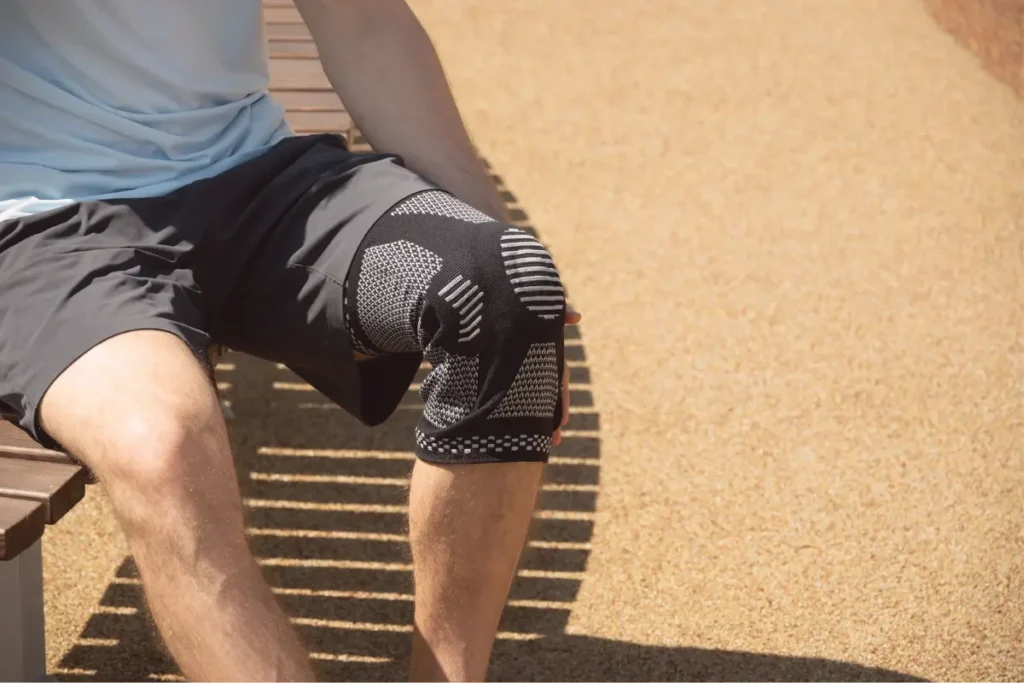 Faixa de compressão no joelho Um homem com faixa de compressão no joelho.